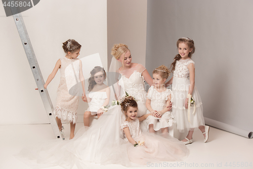 Image of Little pretty girls with flowers dressed in wedding dresses