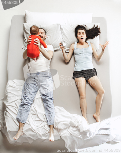 Image of Top view of happy family with one newborn child in bedroom.