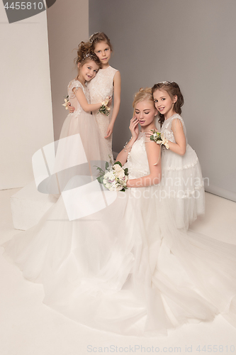 Image of Little pretty girls with flowers dressed in wedding dresses