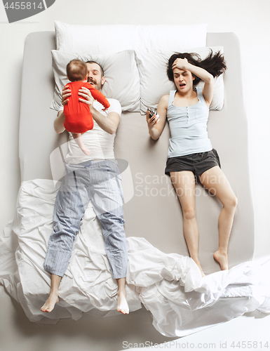 Image of Top view of happy family with one newborn child in bedroom.