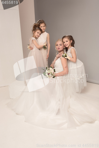 Image of Little pretty girls with flowers dressed in wedding dresses