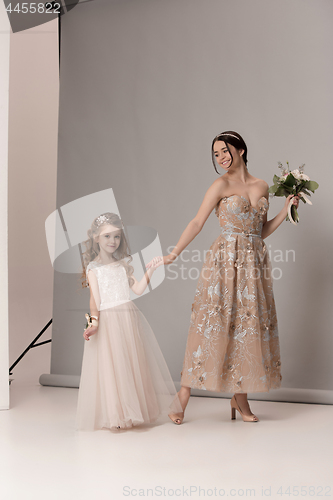 Image of Little pretty girls with flowers dressed in wedding dresses