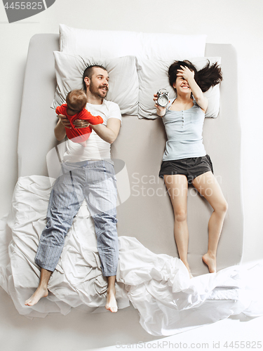 Image of Top view of happy family with one newborn child in bedroom.