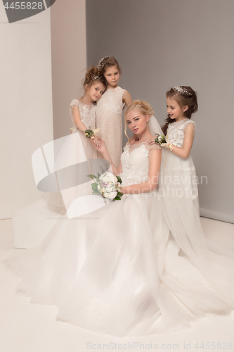 Image of Little pretty girls with flowers dressed in wedding dresses