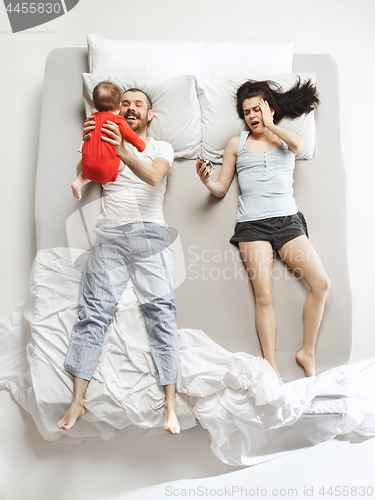 Image of Top view of happy family with one newborn child in bedroom.