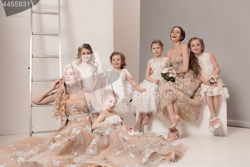 Image of Little pretty girls with flowers dressed in wedding dresses
