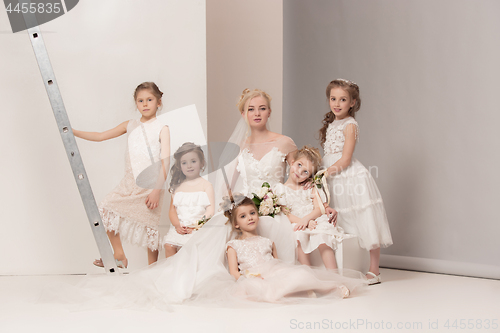 Image of Little pretty girls with flowers dressed in wedding dresses