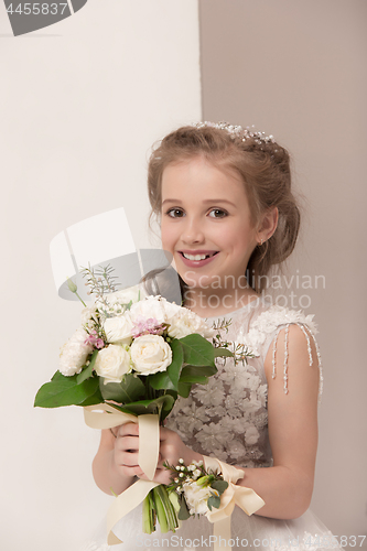 Image of Little pretty girl with flowers dressed in wedding dresses