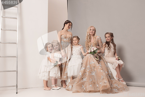 Image of Little pretty girls with flowers dressed in wedding dresses