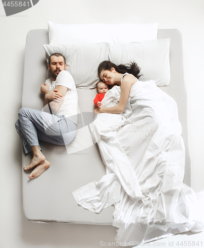 Image of Top view of happy family with one newborn child in bedroom.