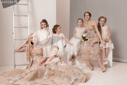 Image of Little pretty girls with flowers dressed in wedding dresses