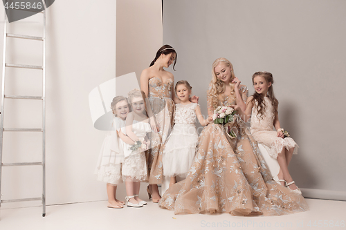 Image of Little pretty girls with flowers dressed in wedding dresses