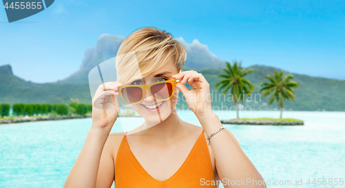 Image of smiling teenage girl in sunglasses over bora bora