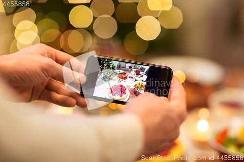 Image of hands photographing food at christmas dinner