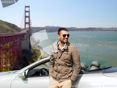 Image of man at convertible car over golden gate bridge