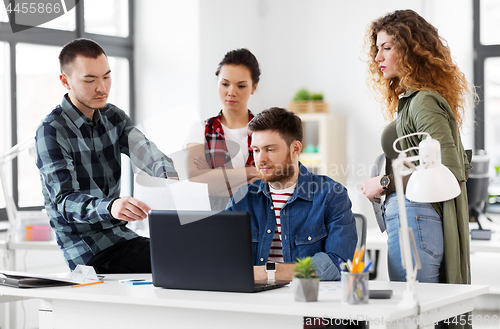 Image of creative team with laptop working at office