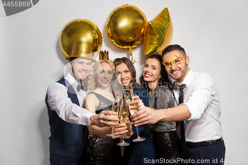 Image of happy friends clinking champagne glasses at party