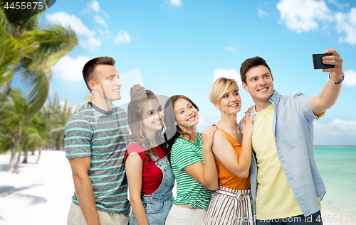 Image of friends taking selfie by smartphone over beach