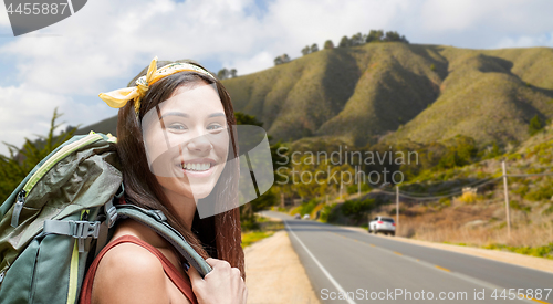 Image of happy woman with backpack hiking over big sur