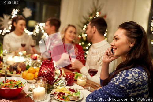 Image of woman calling on smartphone at christmas dinner