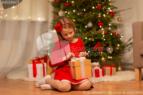 Image of girl with christmas gift at home