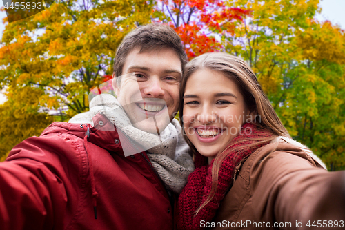 Image of happy couple taking selfie in autumn