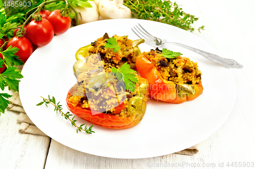 Image of Pepper stuffed with mushrooms and couscous in white plate on tab