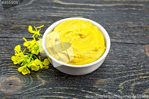 Image of Sauce mustard in bowl with flower on black board