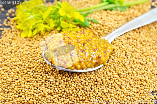 Image of Sauce mustard Dijon in spoon with flower on board