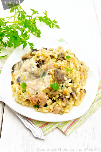 Image of Risotto with mushrooms and chicken on wooden board