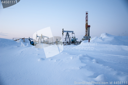 Image of Oil field. Drilling rig and oil pump.