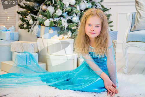 Image of Cute girl sitting near Christmas Tree