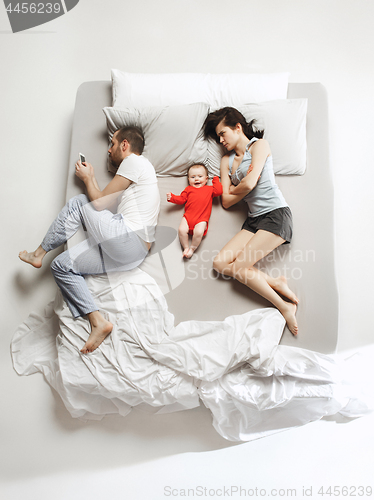 Image of Top view of happy family with one newborn child in bedroom.