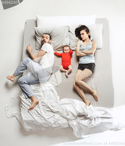 Image of Top view of happy family with one newborn child in bedroom.