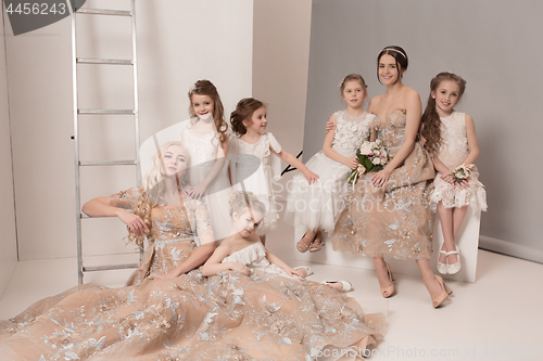 Image of Little pretty girls with flowers dressed in wedding dresses