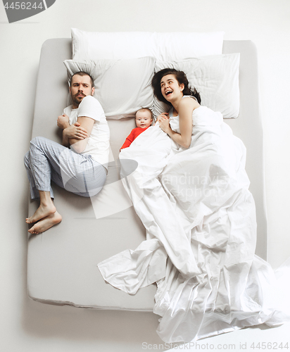 Image of Top view of happy family with one newborn child in bedroom.