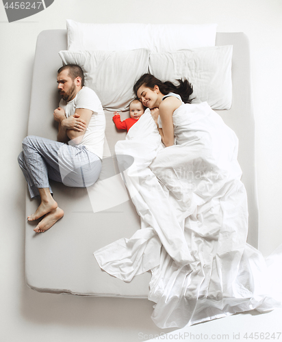 Image of Top view of happy family with one newborn child in bedroom.