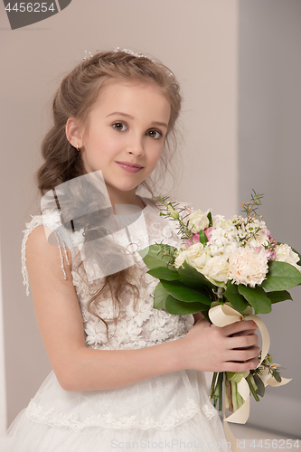 Image of Little pretty girl with flowers dressed in wedding dresses