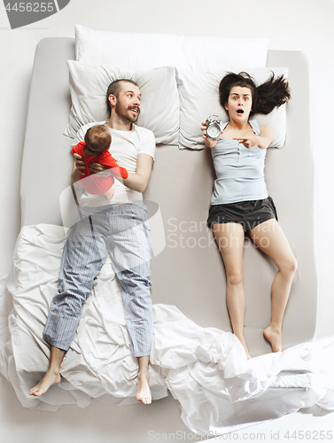 Image of Top view of happy family with one newborn child in bedroom.