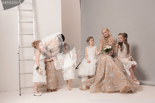 Image of Little pretty girls with flowers dressed in wedding dresses