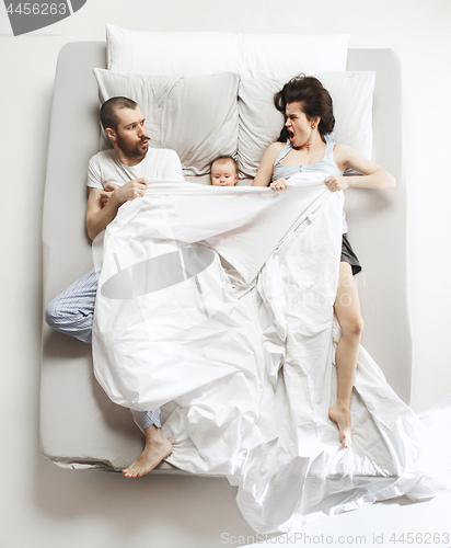 Image of Top view of happy family with one newborn child in bedroom.