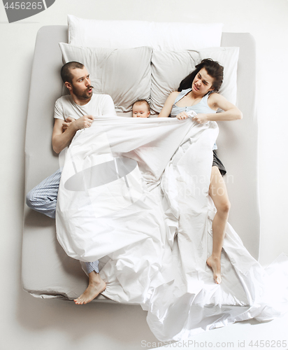 Image of Top view of happy family with one newborn child in bedroom.