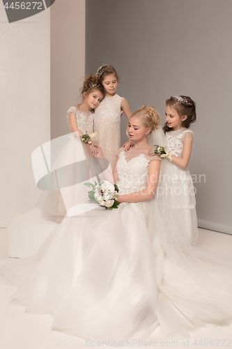 Image of Little pretty girls with flowers dressed in wedding dresses