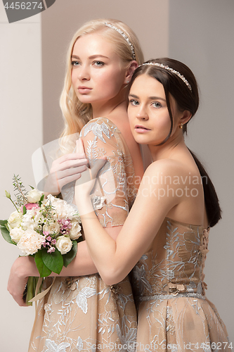 Image of Brides in beautiful dress standing indoors in white studio interior like at home. Trendy wedding style shot. Young attractive caucasian model like a bride tender looking.