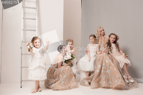Image of Little pretty girls with flowers dressed in wedding dresses