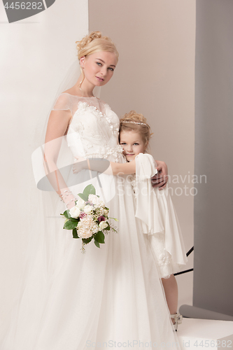 Image of Little pretty girls with flowers dressed in wedding dresses