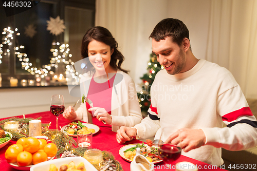 Image of happy couple eating at christmas dinner