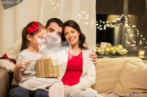 Image of happy family with christmas present at home