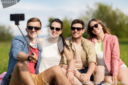 Image of friends taking picture by selfie stick in summer