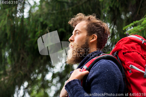 Image of bearded traveler with backpack in woods